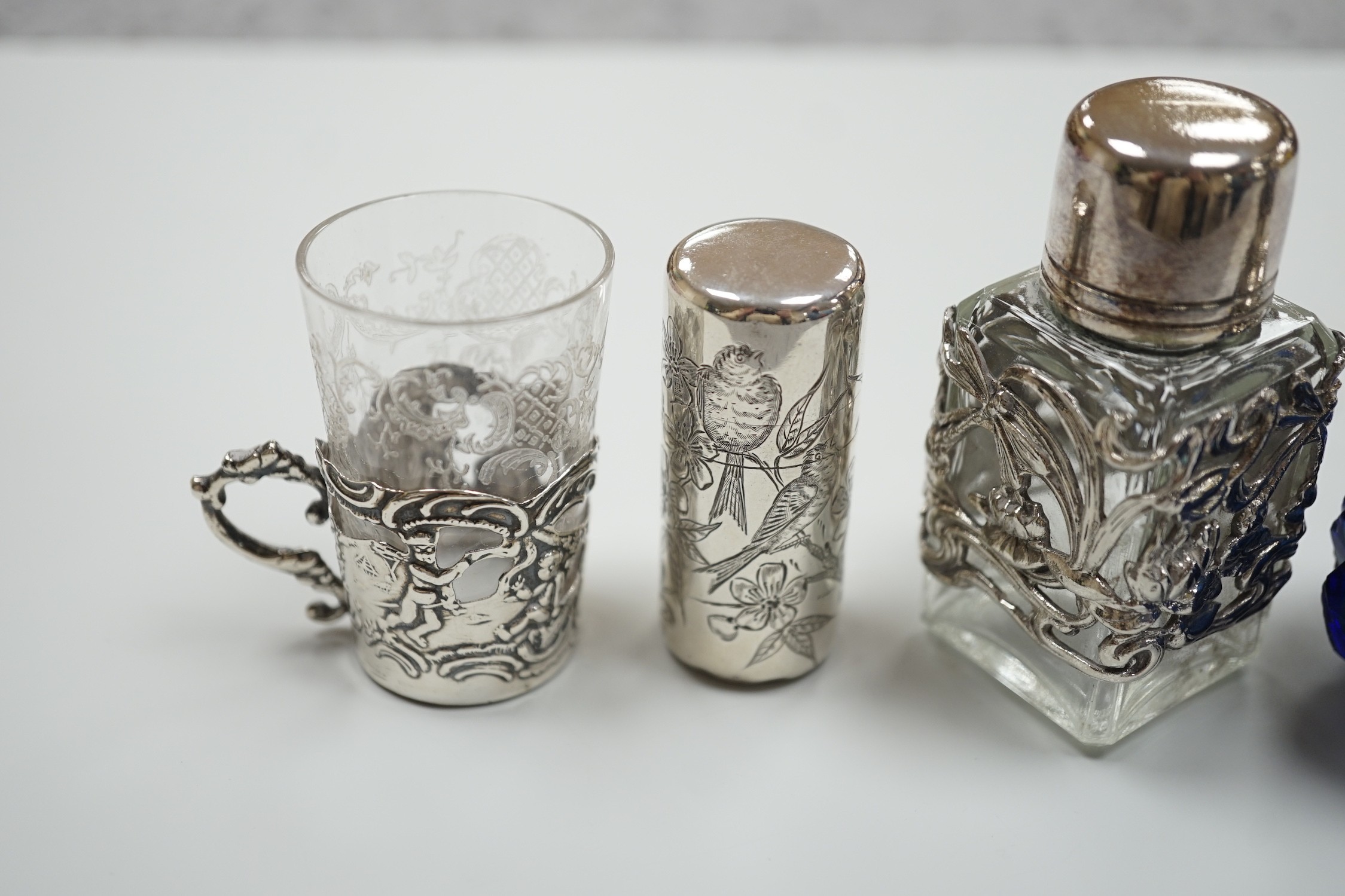 A late Victorian aesthetic engraved silver cylindrical scent bottle, by Sampson Mordan, London, 1881, 54mm, two other mounted glass scent bottles and a similar silver mounted demi tasse cup.